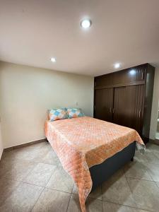 1 dormitorio con 1 cama y armario de madera en Casa hermosa en el centro de la ciudad., en Medellín