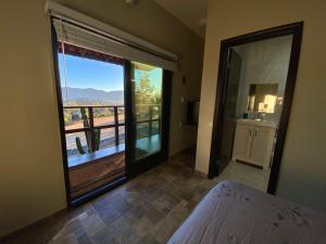 a bedroom with a large window with a view of a balcony at Finca de Lulu y Jose Ruta del Vino in Valle de Guadalupe