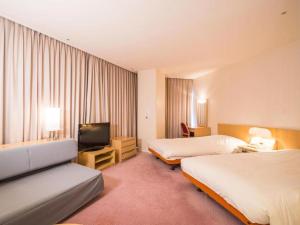 um quarto de hotel com duas camas e uma televisão de ecrã plano em Naeba Prince Hotel em Yuzawa