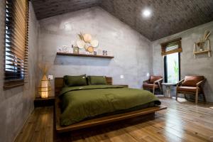 een slaapkamer met een groen bed in een kamer bij Eco House Villa in Phan Thiet