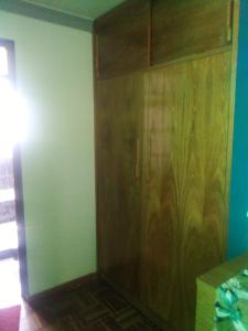 a room with a wooden closet and a wall at Casa Ballesteros Rodríguez in Oruro