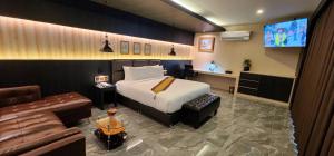 une chambre d'hôtel avec un lit et un canapé dans l'établissement The Room Boutique Hotel, à Sakon Nakhon