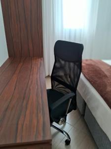 una sedia seduta accanto a un letto accanto a una scrivania di Apto Residencial Monte Carlo em São Roque 01 a São Roque