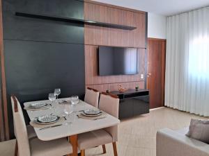 una sala da pranzo con tavolo, sedie e TV di Apto Residencial Monte Carlo em São Roque 01 a São Roque