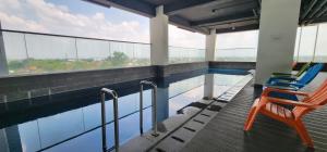 a swimming pool with two chairs and a table at Apartemen Menara One Surakarta by Cariapartemen-id in Sukoharjo