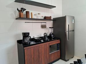 a kitchen with a stove and a refrigerator at Experience Lodging - Monte Carlo 4 in São Roque
