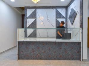 un uomo in piedi dietro una vetrina di Hotel Vibha Palace a Jaipur