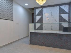 una stanza con un bancone in vetro e un lampadario di Hotel Vibha Palace a Jaipur Altre 21 foto