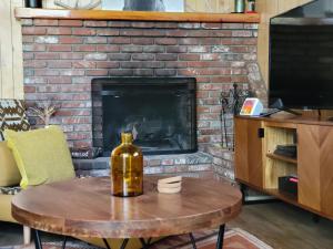 una botella de vino en una mesa frente a la chimenea en Cresta Lunar- Cozy and Modern 2 Bedroom Cabin, en Big Bear Lake
