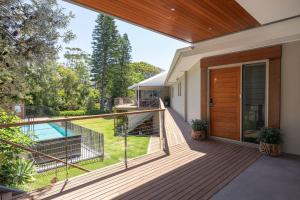 a house with a balcony with a wooden door at Seagull in Mollymook