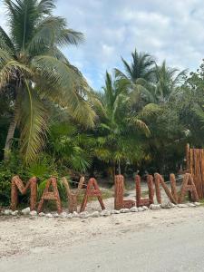 een bord met marmiet op een strand met palmbomen bij Hotel Maya Luna Adults Only in Mahahual