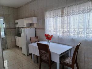 eine Küche mit Tisch und Stühlen und einem Kühlschrank in der Unterkunft Casa Sta Amélia 3 quartos, 3 banheiros c/ garagem in São Roque + 27 Fotos