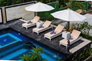 um grupo de cadeiras e guarda-sóis ao lado de uma piscina em Cempaka Lembongan at Mushroom bay em Nusa Lembongan