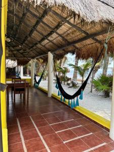 een patio met een hangmat en een tafel op het strand bij Hotel Maya Luna Adults Only in Mahahual