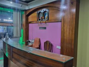 a bar in a restaurant with a pink wall at Hotel Omkar, Tripura in Agartala