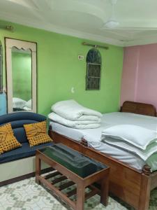 a room with two beds and a chair and a mirror at Hotel Omkar, Tripura in Agartala