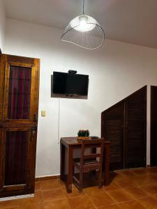 een kamer met een tafel en een tv aan de muur bij Hotel Maya Luna Adults Only in Mahahual