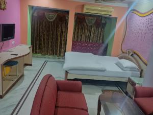 a hospital room with a bed and a desk at Hotel Omkar, Tripura in Agartala