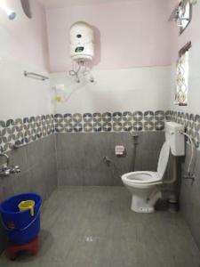 baño con aseo y cubo de basura azul en Yangsel Lodge Tawang en Tawang