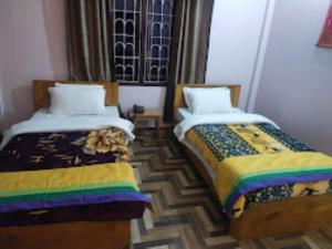 dos camas sentadas una al lado de la otra en una habitación en Yangsel Lodge Tawang en Tawang