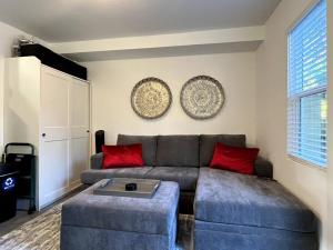 uma sala de estar com um sofá e almofadas vermelhas em The Hudson Suite Spot - Studio Apt Close to ASU em Tempe