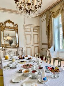 a dining room with a table with food on it at Château La Bainerie in Tiercé
