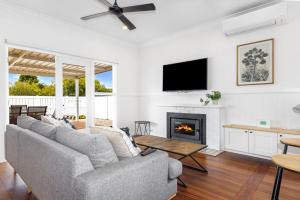 a living room with a couch and a fireplace at Fairbairn Family Beach Bungalow in Busselton