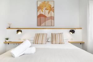 a bedroom with a white bed with two pillows at Fairbairn Family Beach Bungalow in Busselton