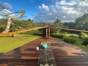 a wooden bench on a deck with a view at Avocado Retreat in Rarotonga +17 photos