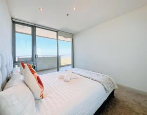 una camera da letto con un letto bianco e una grande finestra di Share House Master Room Near Chatswood Station a Sydney