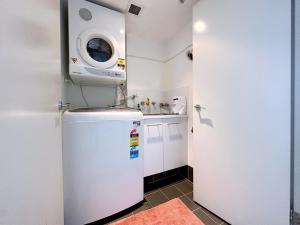 uma pequena cozinha com um lavatório e um micro-ondas em Share House Master Room Near Chatswood Station em Sidney