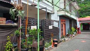 a building with potted plants on the side of it at Spot On 93382 Gajayana Kost Female Only Syariah in Jenggrik