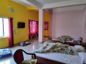 a room with two beds in a room with yellow walls at Hotel Keeduk Inn Dirang in Dirang Dzong