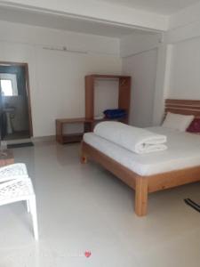 1 dormitorio con 1 cama y 1 silla en Hotel Keeduk Inn Dirang, en Dirang Dzong