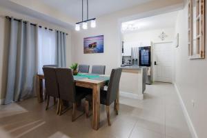cocina y comedor con mesa y sillas en Welcome to our Ocean View Villa!, en Lucea