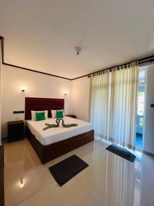 a bedroom with a large bed and a large window at Lemazone Inn in Mirissa