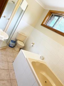 baño con bañera, aseo y ventana en Bellview Estate, Bilpin, en Bilpin