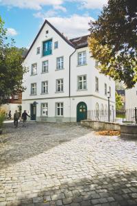 duży biały budynek z ludźmi idącymi przed nim w obiekcie HOTEL BLAUE ROSE -digital check in- w mieście Feldkirch