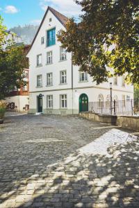 un gran edificio blanco con una calle adoquinada en HOTEL BLAUE ROSE -digital check in-, en Feldkirch