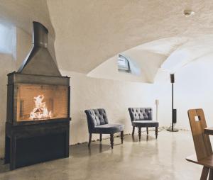 sala de estar con chimenea y 2 sillas en HOTEL BLAUE ROSE -digital check in-, en Feldkirch