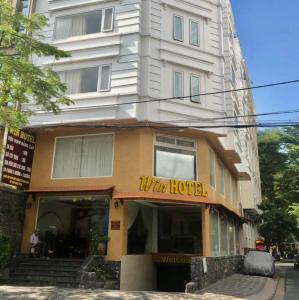 un edificio con un hotel frente a él en Win Hotel - 43 Đường số 10, KDC Trung Sơn, Bình Chánh- by Bay Luxury en Ho Chi Minh