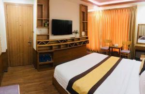 Habitación de hotel con cama y TV de pantalla plana. en Win Hotel - 43 Đường số 10, KDC Trung Sơn, Bình Chánh- by Bay Luxury en Ho Chi Minh