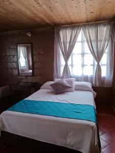 a bedroom with a large bed with a window at Alojamiento Campestre San Carlos in Montenegro