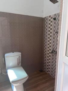 a bathroom with a white toilet and a shower at Beach Paradise in Matara