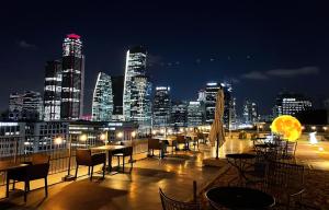 a view of a city skyline at night with tables and chairs at GLAD Yeouido in Seoul