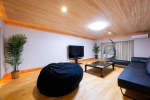 a living room with a couch and a table at Hinoki house in Fukuoka