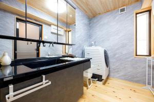 a kitchen with a sink and a fan at Hinoki house in Fukuoka