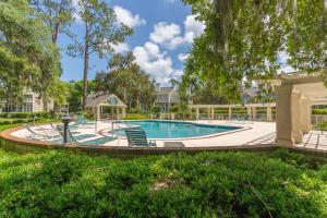 uma piscina num quintal com cadeiras e árvores em Low Country em Harrington