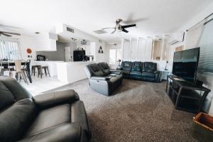 a living room with couches and a television and a kitchen at Pebble Creek in Three Rivers