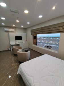 a bedroom with a bed and a view of the ocean at Marina Town in Sohar